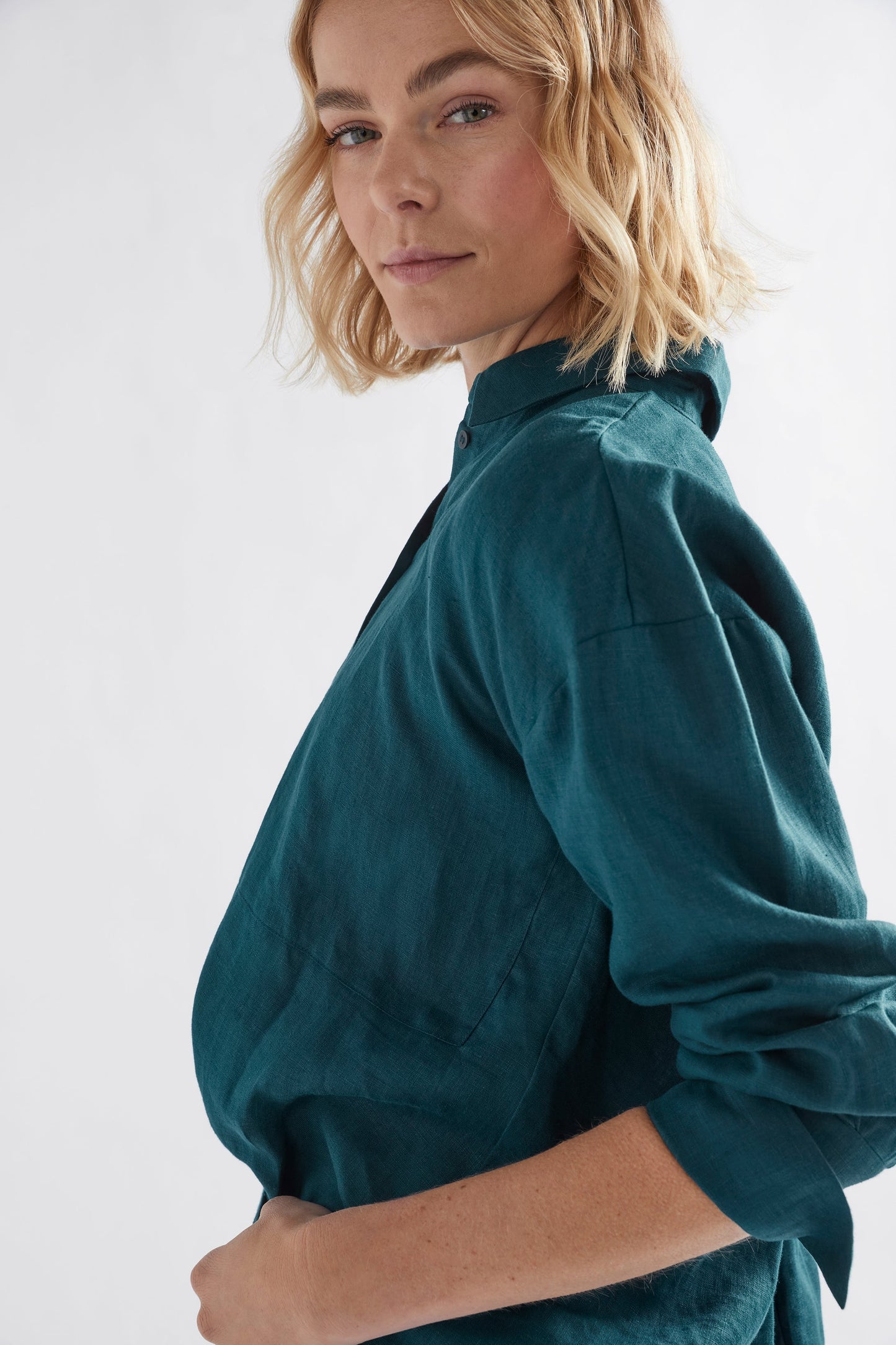 Stilla Linen Shirt with High-Low Hem and Back Pleat Detail Model side | PEACOCK